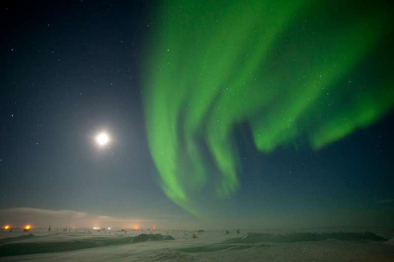 The green northern lights with a full moon