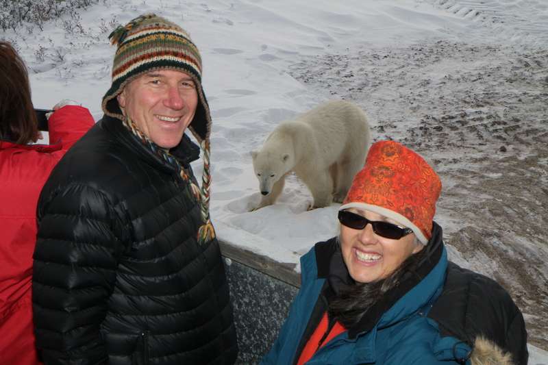 People pose with a polar bear on the tundra