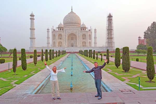 A couple posing at a crowd-free Taj Mahal in India