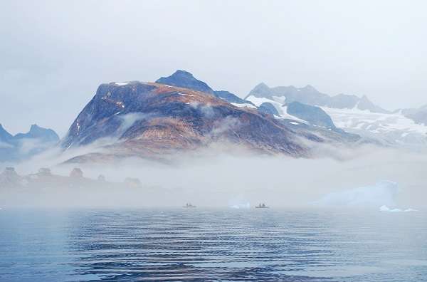 Thick fog shrouds kayakers and icebergs alike near the tiny village of Tinit in eastern Greenland. Natural Habitat’s Base Camp Greenland is located across the bay. 