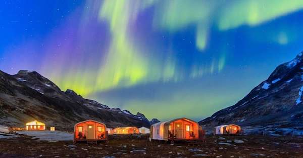 Base Camp Greenland with northern lights overhead.