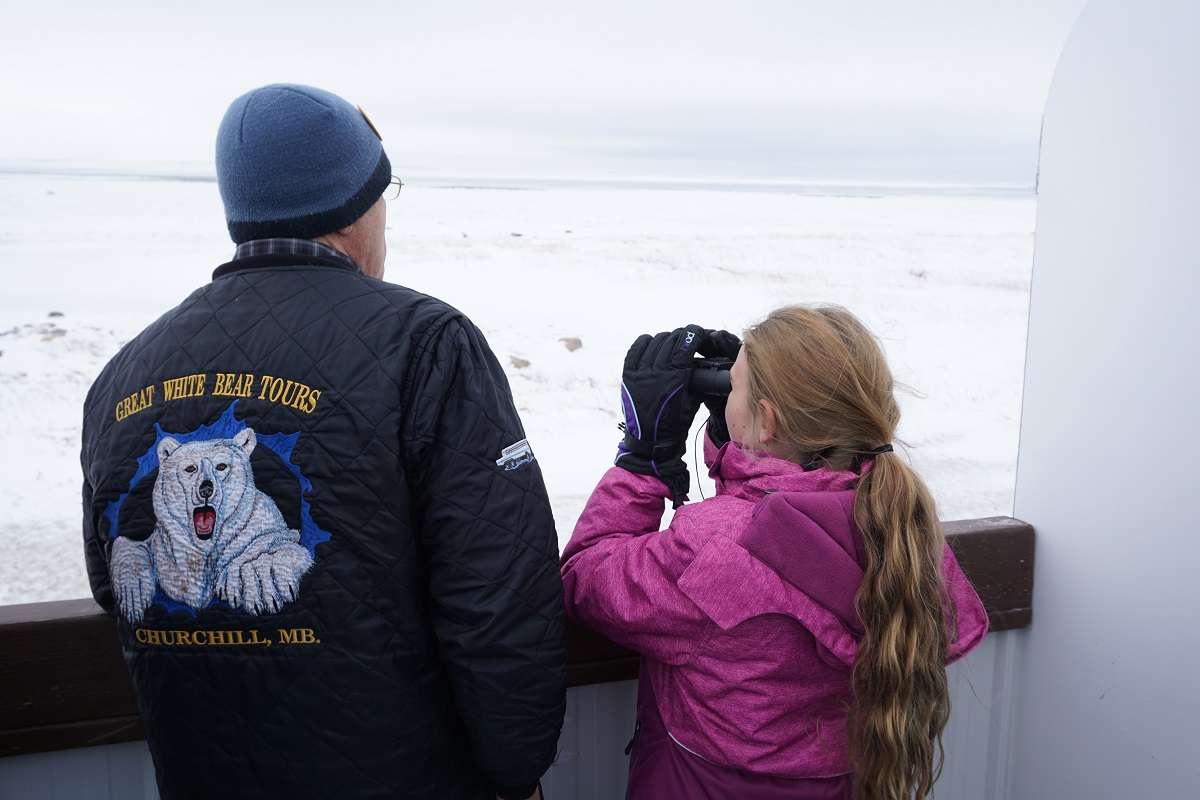 Child and guide look for polar bears in Churchill. 
