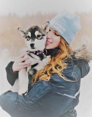 Snuggling with a husky pup in the Canadian Arctic.