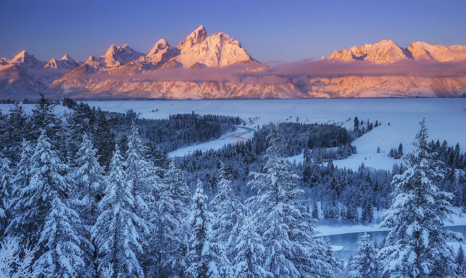 The winter sun rises over the Snake River Overlook in Grand Teton National Park, Wyoming.
