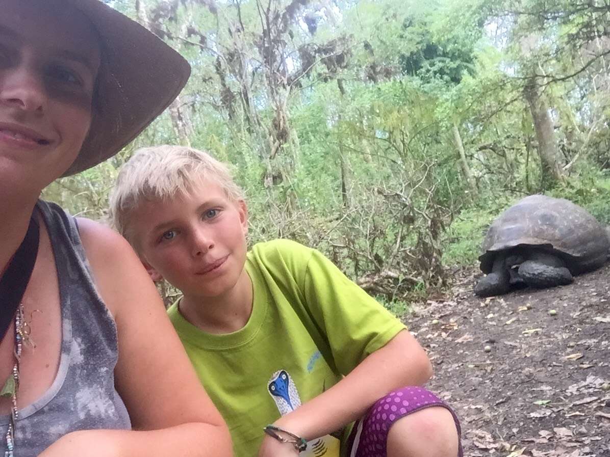 A mom and son see a giant tortoise on a Family Galapagos Adventure. 