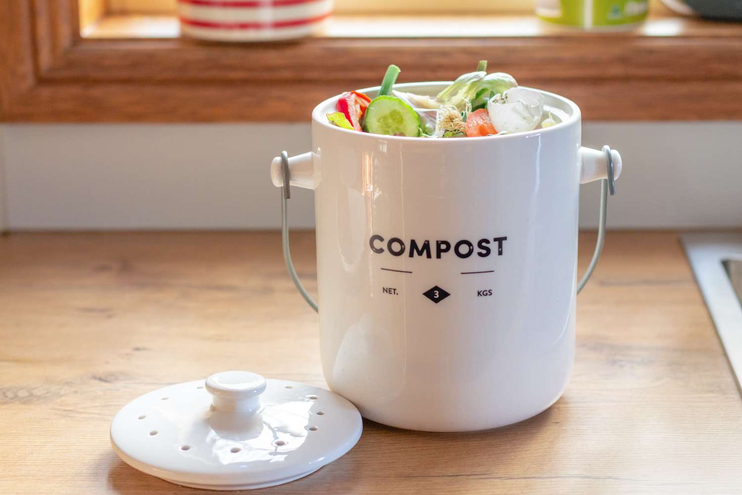kitchen waste compost pot containing kitchen waste on kitchen counter top, sustainable living organic waste recycling,