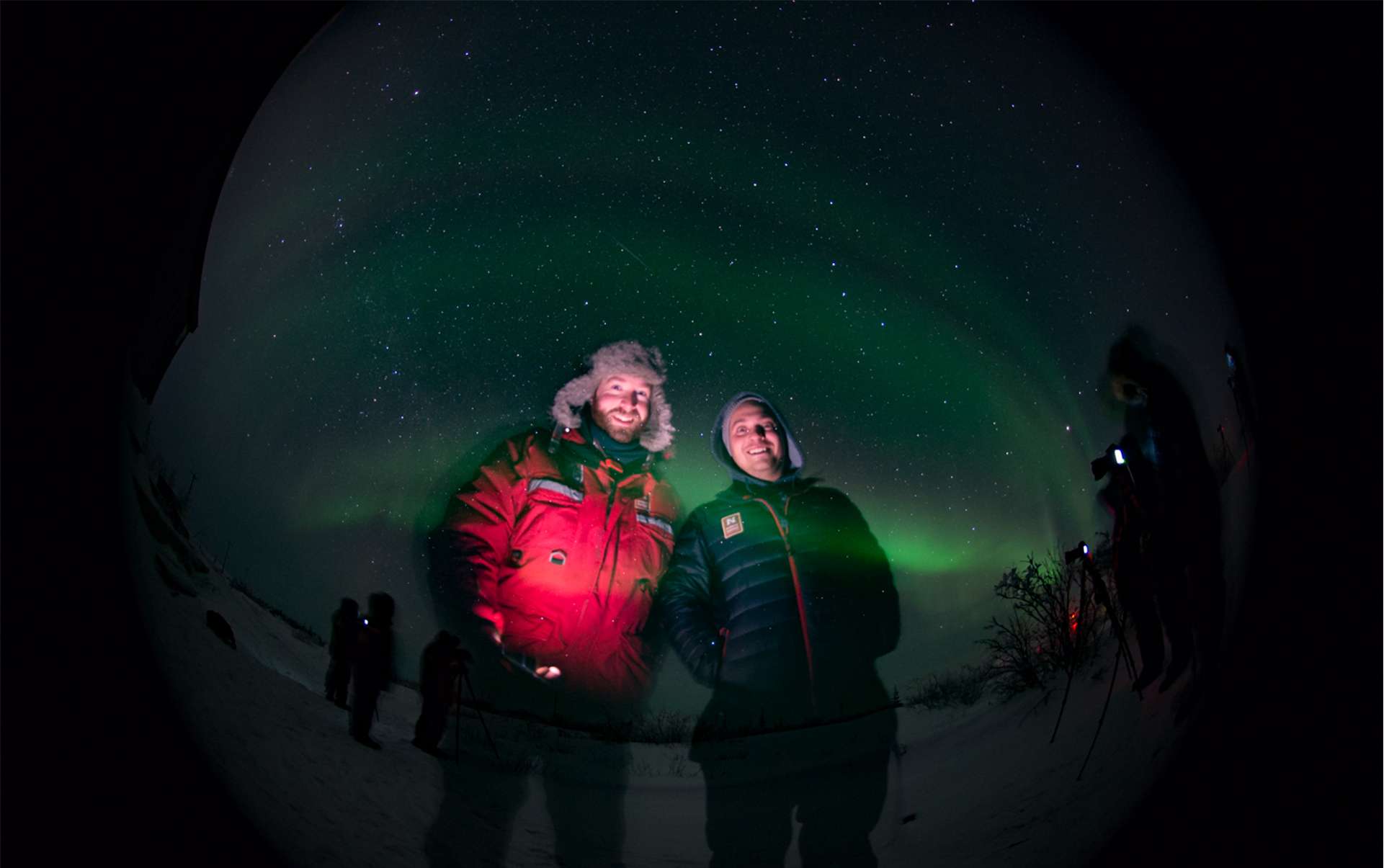 Natural Habitat Adventures and WWF guests and guides taking a selfie under Churchill’s northern lights
