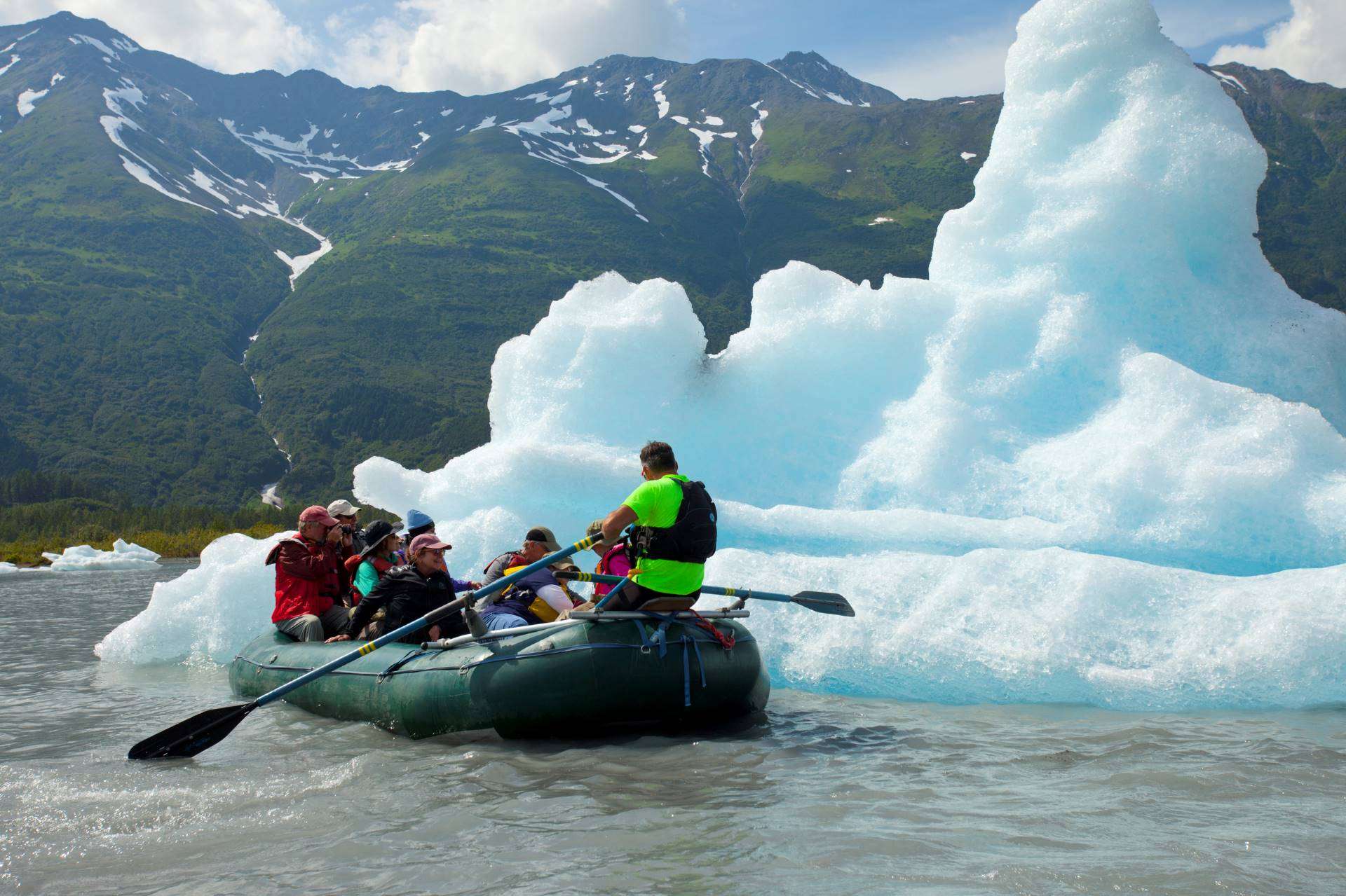 Nat Hab travelers raft past an iceberg in Alaska by Court Whelan