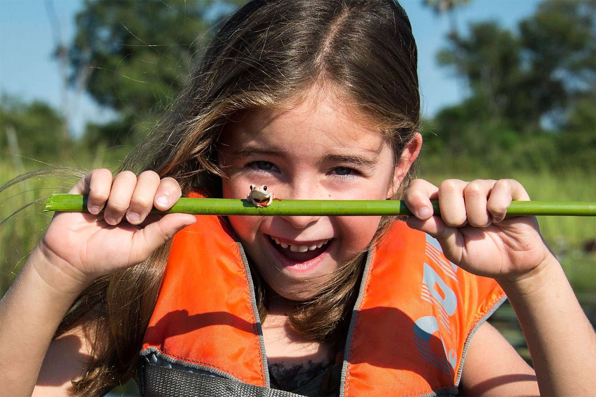 Girl smiling excited holding tree frog