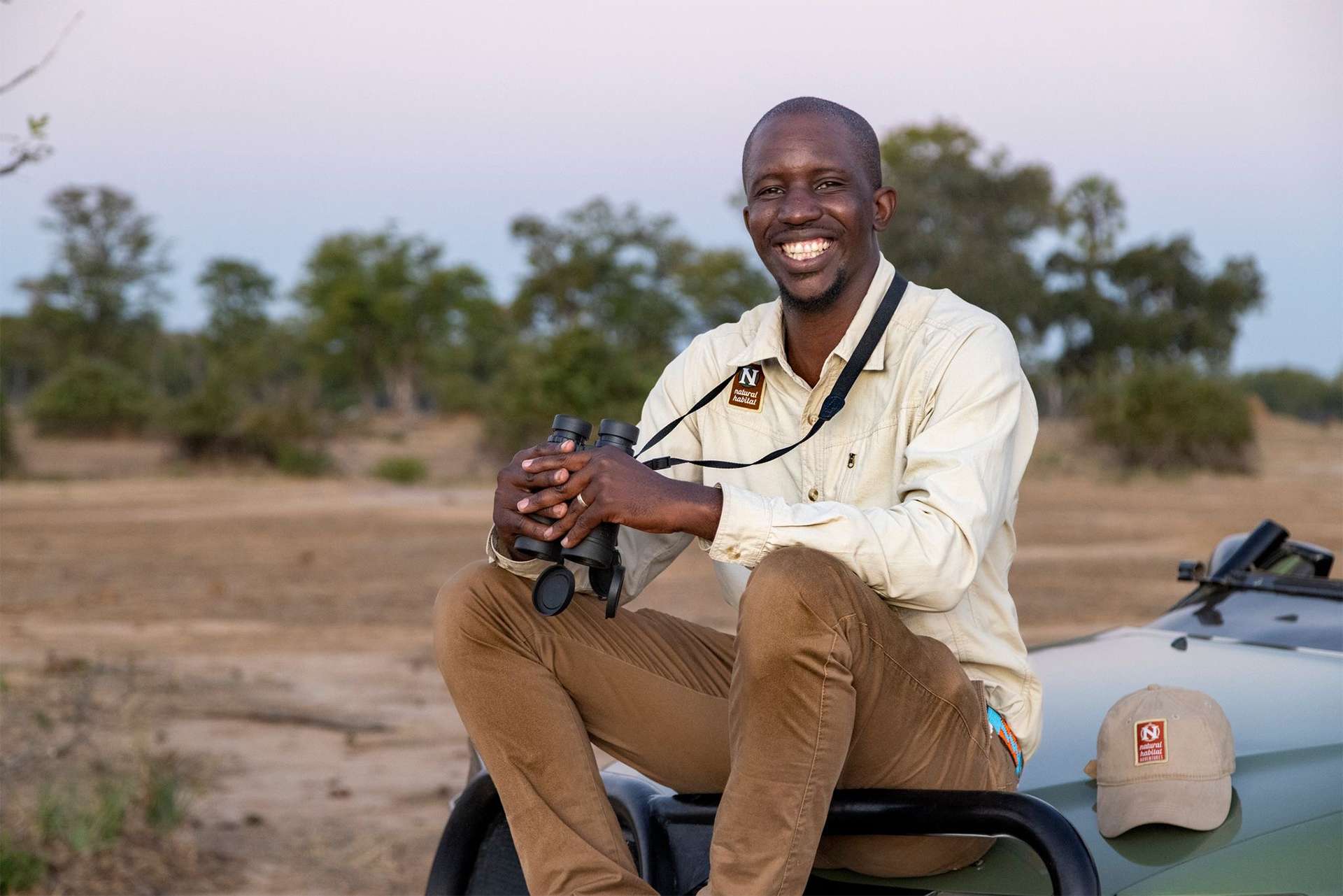 Zimbabwe Nat Hab naturalist guide wildlife Expedition Leader laughing smiling joyful using binoculars 