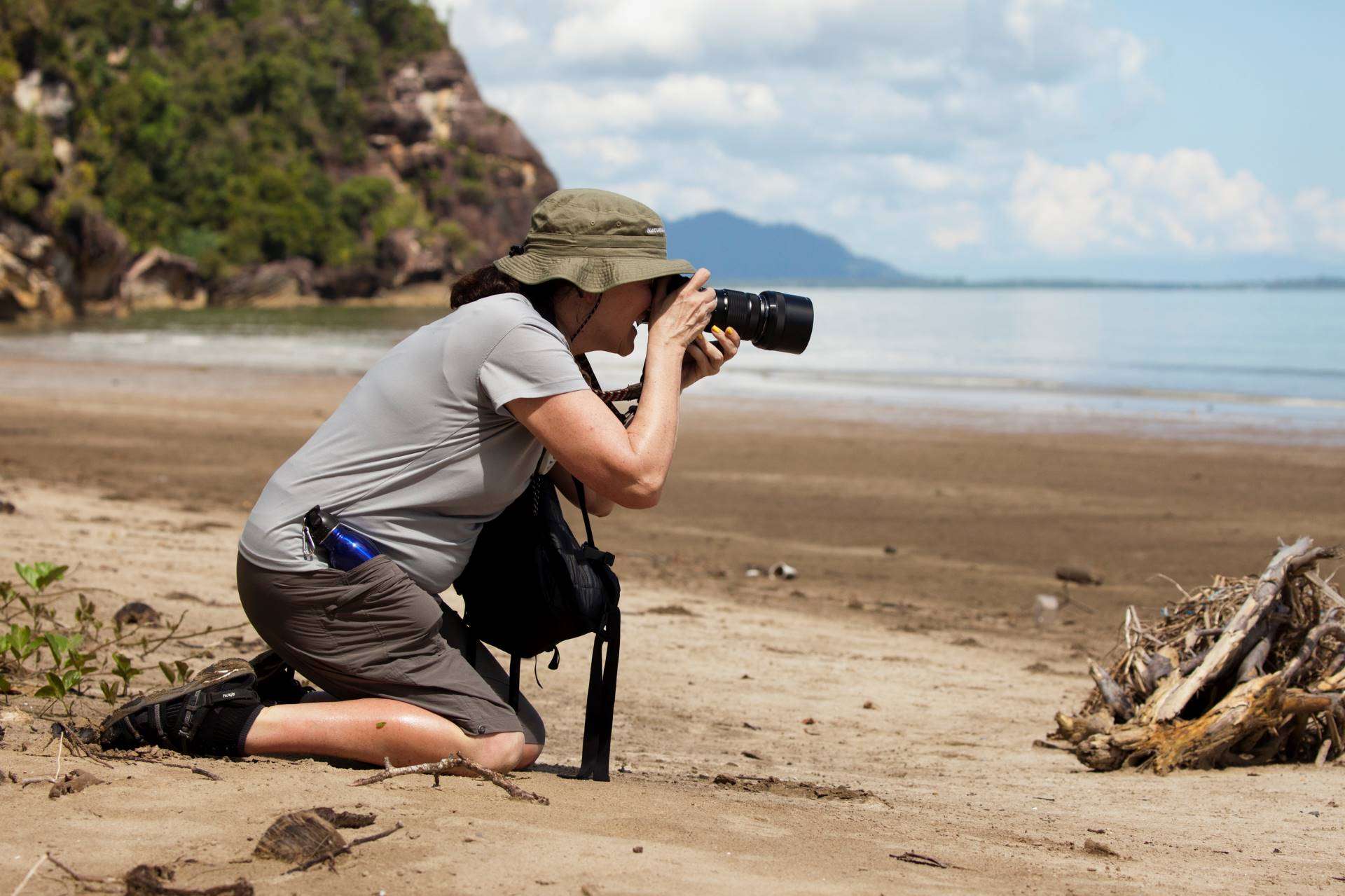 Woman taking photos of birds on the beach in Borneo
