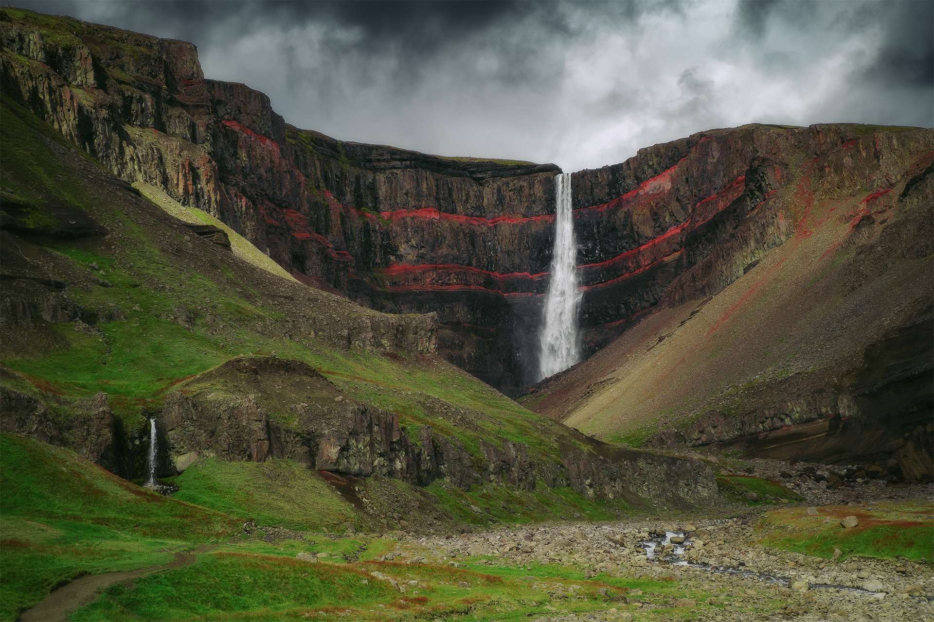 Hengifoss waterfall landscape in East Iceland. Red layers of clay between the basaltic layers