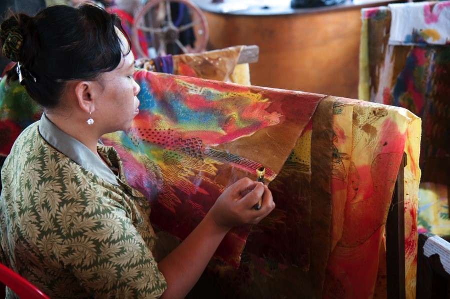 A local woman uses natural dyes to design a traditional batik in Bali