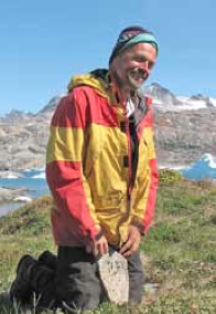 Olaf Malver smiling in the mountains while wearing a yellow and red jacket